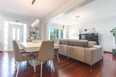 a dining room with a couch and a table and chairs at Villa Alves by Altlantic Holiday in Faial