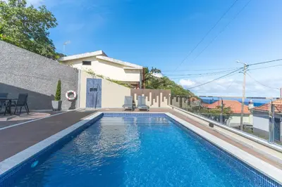 a swimming pool in front of a house at Villa Alves by Altlantic Holiday in Faial