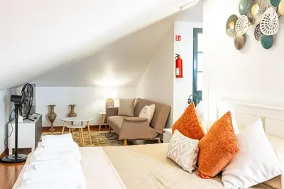 a bedroom with a bed and a couch and a table at Horizonte Azul in Ponta do Sol