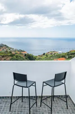 two chairs on a balcony with a view of the ocean at Horizonte Azul in Ponta do Sol