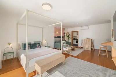 a bedroom with a canopy bed and a living room at Lido Ocean View - Perto da Praia com Estacionamento Privado in Funchal