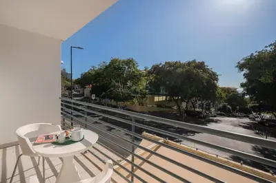 a balcony with a table and chairs and a view of a street at Lido Ocean View - Perto da Praia com Estacionamento Privado in Funchal