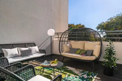 a balcony with two chairs and a bird cage at Lido Ocean View - Perto da Praia com Estacionamento Privado in Funchal