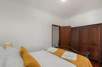 a bedroom with a bed and a wooden cabinet at Villa Mirage - by Madeira To Stay in Arco da Calheta