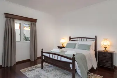 a bedroom with a bed and two lamps and a window at Villa Mirage - by Madeira To Stay in Arco da Calheta