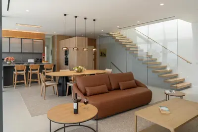 a living room with a couch and a staircase at OurMadeira - GrandView Cristo Rei in Caniço