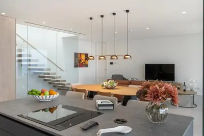 a kitchen and living room with a table and a dining room at OurMadeira - GrandView Cristo Rei in Caniço