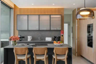 a kitchen with a island with chairs and a counter top at OurMadeira - GrandView Cristo Rei in Caniço