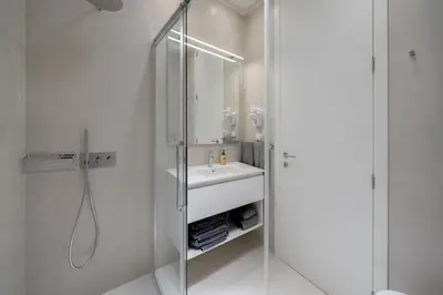 a white bathroom with a sink and a shower at OurMadeira - GrandView Cristo Rei in Caniço