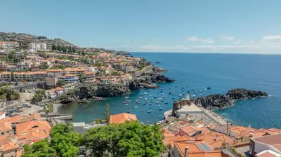 a view of a town with boats in the water at Bay View Traditional house in city center in Câmara de Lobos