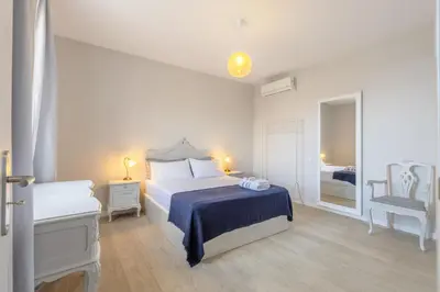 a white bedroom with a bed and a window at Bay View Traditional house in city center in Câmara de Lobos