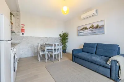 a living room with a blue couch and a table at Bay View Traditional house in city center in Câmara de Lobos