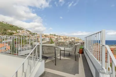 a balcony with chairs and a view of the ocean at Bay View Traditional house in city center in Câmara de Lobos