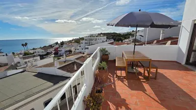 a balcony with a table and an umbrella at Margarida Seaview Terrace Apartment in Luz