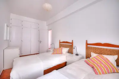 two beds in a bedroom with white walls at Margarida Seaview Terrace Apartment in Luz
