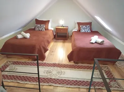two beds in a attic room with a staircase at The Goat's Place III in Gaula