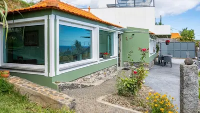 a green house with large windows and a patio at The Goat's Place III in Gaula