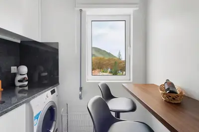a kitchen with a washing machine and a window at Machico Bay in Machico