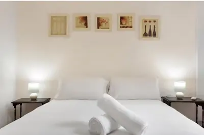 a white bedroom with two beds and two lamps at Machico Bay in Machico