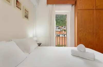 a bedroom with a white bed and a window at Machico Bay in Machico