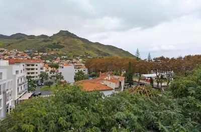 a view of a city with a mountain in the background at Machico Bay in Machico