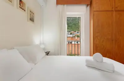 a bedroom with a white bed and a window at Machico Bay in Machico