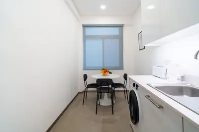 a kitchen with a sink and a table with chairs at Carmo Downtown Apartment by Amazing Madeira in Funchal