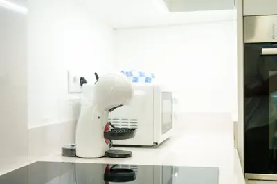 a white mixer sitting on a counter next to a microwave at Carmo Downtown Apartment by Amazing Madeira in Funchal