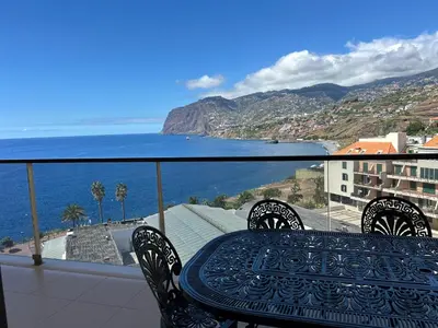 a table and chairs on a balcony overlooking the ocean at Ocean Sea View Apartment in Funchal