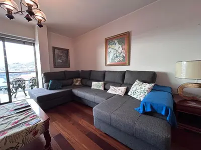 a living room with a gray couch and a window at Ocean Sea View Apartment in Funchal