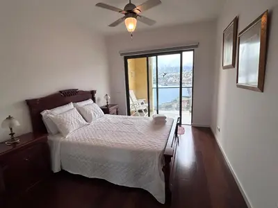 a bedroom with a bed and a ceiling fan at Ocean Sea View Apartment in Funchal