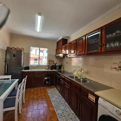 a kitchen with wooden cabinets and a counter top at JoLi Larano - APT with 3 bedroom and 2 wc in Machico