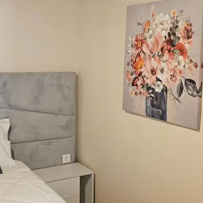 a bedroom with a painting of flowers on the wall at JoLi Larano - APT with 3 bedroom and 2 wc in Machico