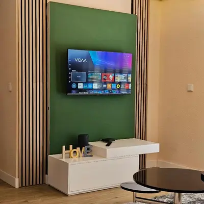 a room with a tv on a green wall at JoLi Larano - APT with 3 bedroom and 2 wc in Machico