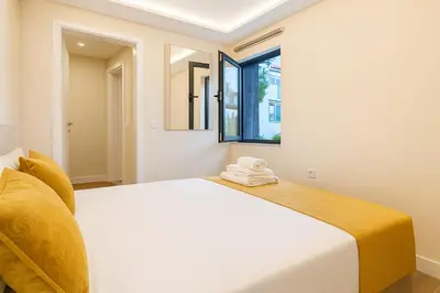 a bedroom with a white bed and a window at JoLi Larano - APT with 3 bedroom and 2 wc in Machico