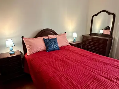 a bedroom with a bed with a red bedspread and a mirror at Lido Funchal in Funchal