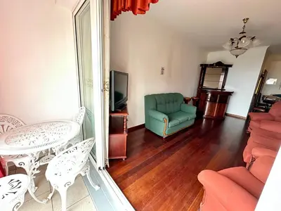 a living room with a couch and a table and a tv at Lido Funchal in Funchal