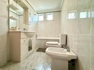 a white bathroom with a sink and a toilet at Lido Funchal in Funchal