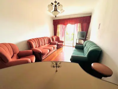 a living room with couches and a tv at Lido Funchal in Funchal