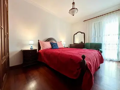 a bedroom with a bed with a red blanket and a mirror at Lido Funchal in Funchal