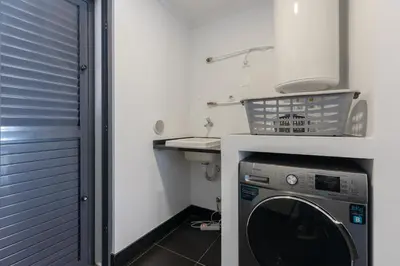 a laundry room with a washer and a sink at Sea View Apartment in Caniço