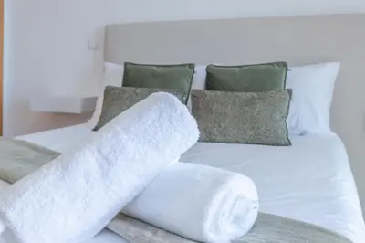 a white bed with two towels on it at Sea View Apartment in Caniço