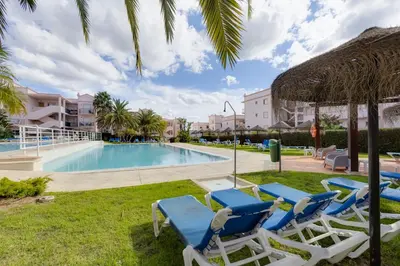 a swimming pool with lounge chairs and a resort at Beachside oasis with Pool in Luz