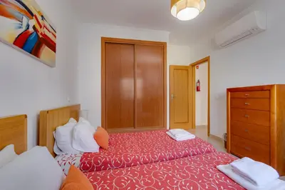 a bedroom with a large bed and a dresser at Beachside oasis with Pool in Luz