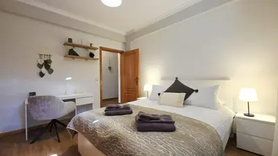 a bedroom with a bed and a desk and a chair at Casa Amarela - Estreito de Câmara de Lobos in Estreito de Câmara de Lobos