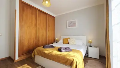 a bedroom with a bed with two towels on it at Casa Amarela - Estreito de Câmara de Lobos in Estreito de Câmara de Lobos