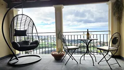 a balcony with two chairs and a table with a view at Casa Amarela - Estreito de Câmara de Lobos in Estreito de Câmara de Lobos