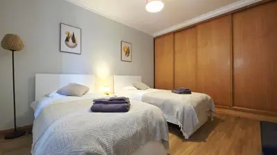 a bedroom with two beds with towels on them at Casa Amarela - Estreito de Câmara de Lobos in Estreito de Câmara de Lobos