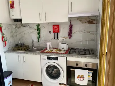 a kitchen with a stove and a washing machine at Vista Clara in Ponta do Sol