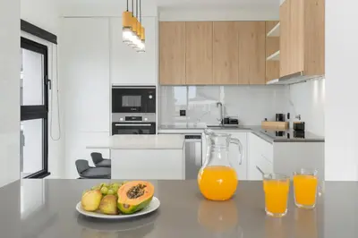 a table with a plate of fruit and two glasses of orange juice at Apartamento São Lucas I by An Island Apart in Funchal